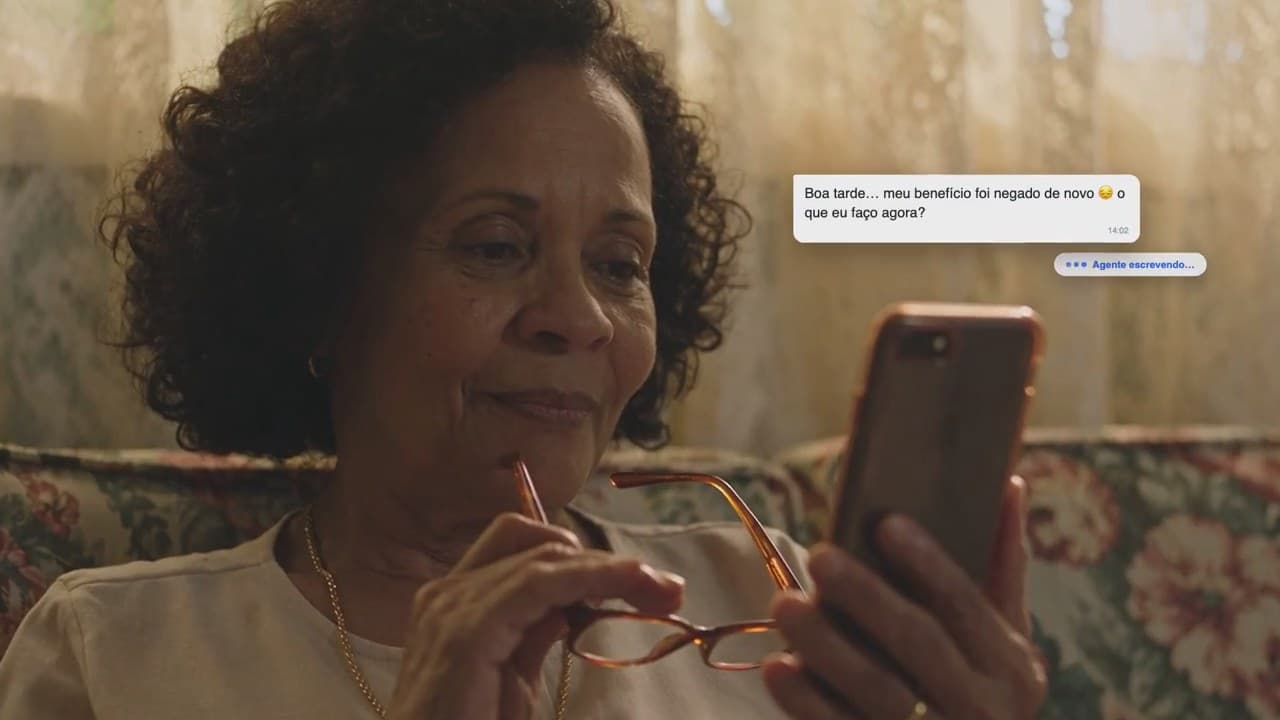 Cliente sorrindo enquanto lê no celular a resposta do escritório